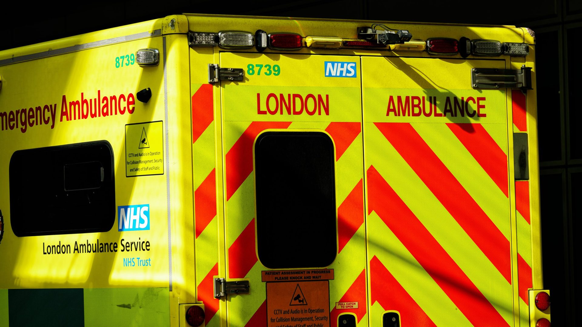 NHS National Health Service Vehicle Rear View, London Ambulance Service LAS, Medical Emergency Vehicle With Reflective Battenburg Markings In London, England, UK, March 2025