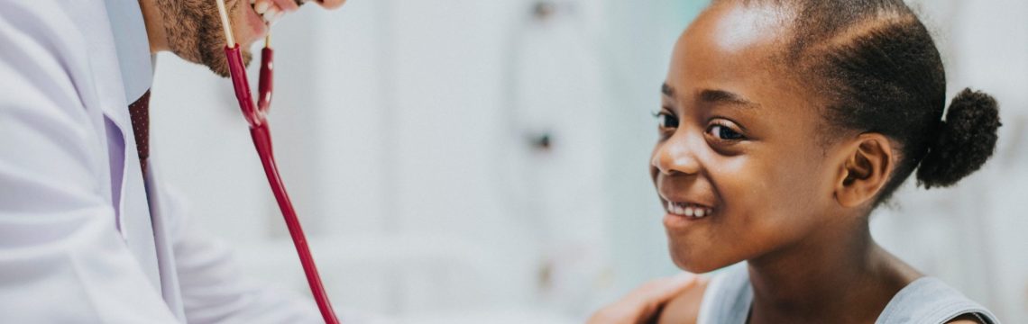 Friendly pediatrician checking a little girls heart
