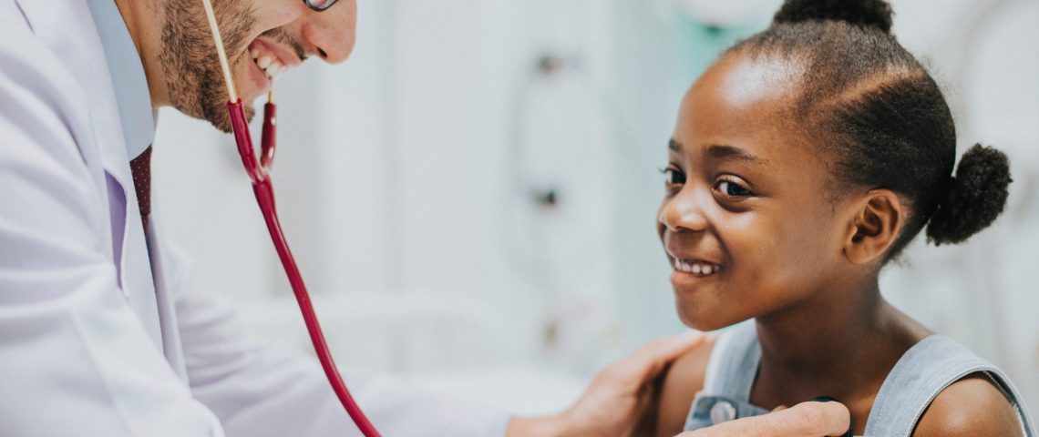 Friendly pediatrician checking a little girls heart