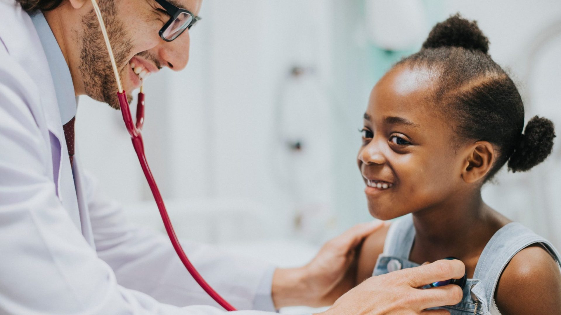 Friendly pediatrician checking a little girls heart