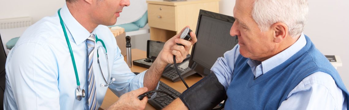 British doctor taking senior man's blood pressure