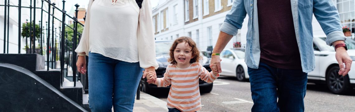 Family in the city walking holding hands.