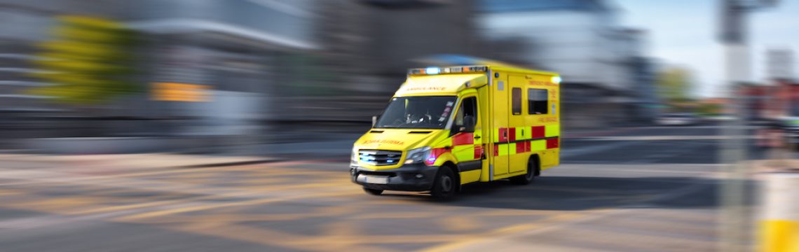 Ambulance responding to emergency call driving fast on street